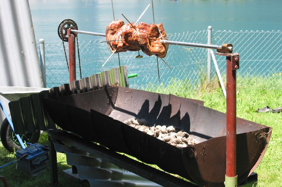 Spanferkel auf dem Grill mit dem See im Hintergrund